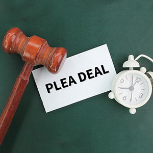 Gavel and alarm clock next to a PLEA DEAL card, explaining Georgia Criminal Cases and legal proceedings.
